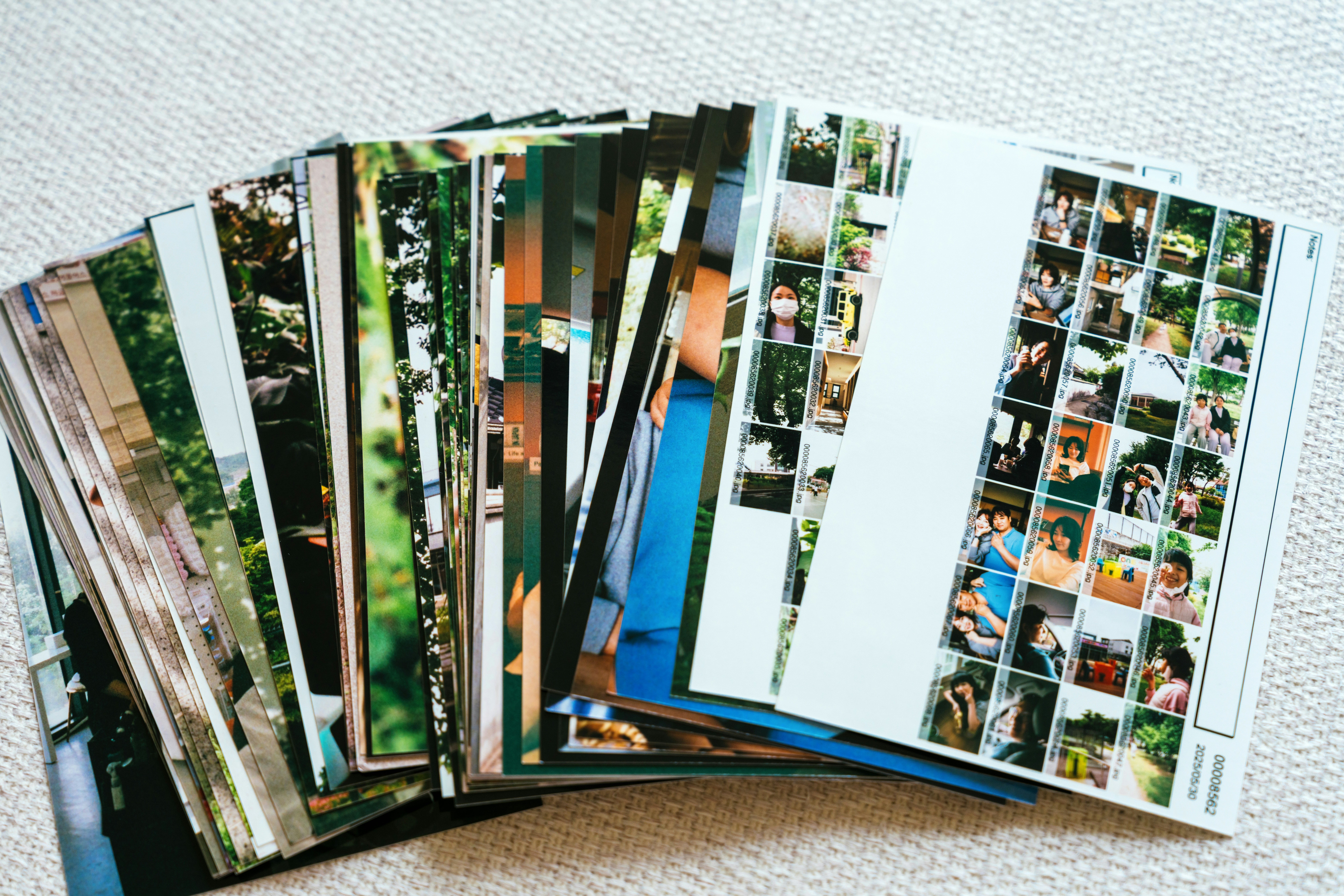 A collection of photographs is fanned out on a table.